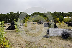 Space for playing paintball with the paint marks after fights. Abandoned paintball playground with barricades made of old tires