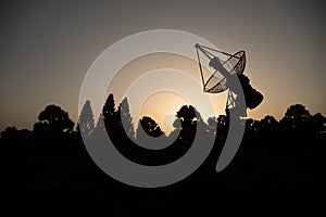 Space radar antenna on sunset. Silhouettes of satellite dishes or radio antennas against night sky. Space observatory or Air