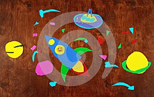 Space rocket and planets, solar system, Astronautics and space alien on wooden background-application made by child photo