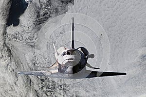 Space ship shuttle flying near earth from the hurricane and massive clouds in atmosphere, image made of NASA photos f