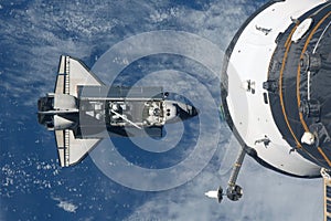Space shuttle flies under the space station. Elements of this image were furnished by NASA