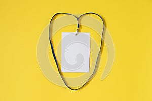 Empty ID card badge icon with blue belt in heart shape on yellow background.