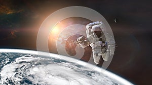 Spaceman is flying in outer space on Earth background. Elements of this image furnished by NASA