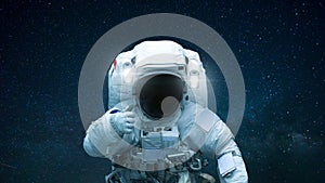 Spaceman in open space with hand shows like. Astronaut travels in space against the background of stars.