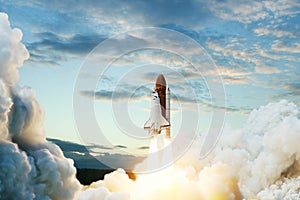 Spaceship lift off. Space shuttle with smoke and blast takes off into space on a background of blue sky.