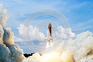 Spaceship lift off. Space shuttle with smoke and blast takes off into space on a background of blue sky.