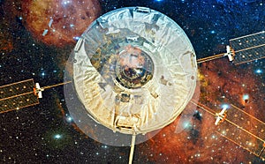 Spaceship in outer space against the background of the nebula.