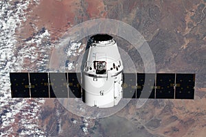 The SpaceX Dragon resupply ship is pictured approaching the International Space Station. Elements of this image