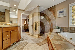 Spacious bathroom with corner bath tub and open shower