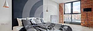 Spacious bedroom with industrial style wall, panorama