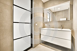 Spacious beige bathroom with shower cabin