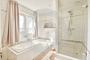 Spacious beige bathroom with shower cabin