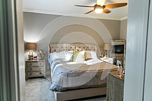 Spacious beige carpeted master bedroom with king sized bed