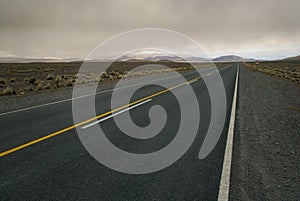 Spacious cloudy landscape crossed by empty road photo