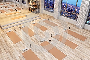Spacious concrete yoga gym interior with equipment, night city view and wooden flooring. Healthy lifestyle concept.