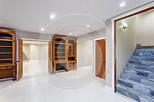 Spacious empty basement area with custom built bookcases.