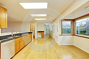 Spacious kitchen room with cabinets and black granite tops.