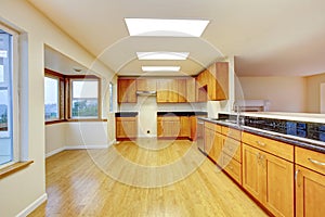 Spacious kitchen room with cabinets and black granite tops.