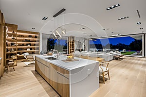 Spacious kitchen with wooden floors, a large white island, and abundant natural light.
