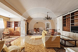 A spacious living room in a house with antique furniture with a yellow fabric