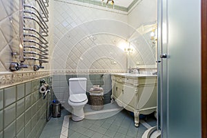 Spacious luxury bathroom with toilet, shower and washbasin. The walls are lined with expensive