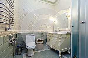 Spacious luxury bathroom with toilet, shower and washbasin. The walls are lined with expensive
