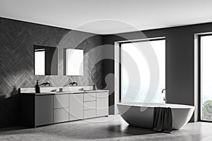 Spacious modern bathroom design interior in gray tones with concrete floor, freestanding tub, double sink vanity. Panoramic window