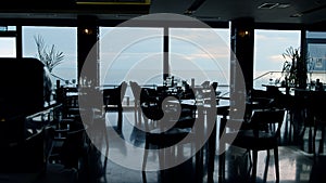 Spacious panoramic restaurant interior in evening dusk. Business lunch concept