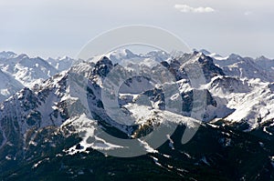 A spacious panoramic view of the Alps mountains partially covered with the snow