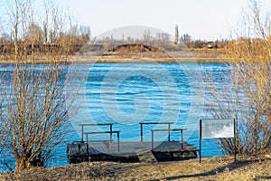 Spacious pedestrian pier made of wood on pontoons, easy boarding in boats or fishing