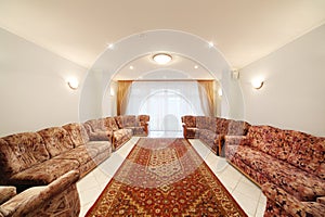 A spacious room with sofas and carpet on the