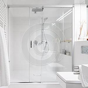 Spacious shower behind glass sliding doors