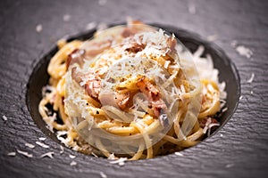 Spagetti carbonara on a black plate