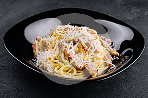 Spagetti carbonara on a black plate