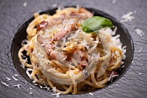 Spagetti carbonara on a black plate