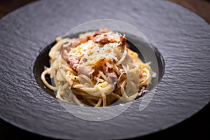 Spagetti carbonara on a black plate