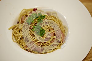 Spaghetti Aglio Olio with bacon, garlic, dry red chili and parsley on dish