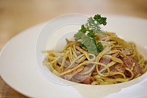Spaghetti Aglio Olio with bacon, garlic, dry red chili and parsley on dish