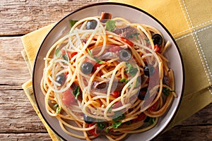 Spaghetti alla putanesca with anchovies, tomatoes, garlic and bl photo