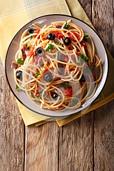 Spaghetti alla putanesca with anchovies, tomatoes, garlic and bl photo