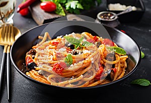 Spaghetti alla puttanesca - italian pasta dish with tomatoes, black olives, capers, anchovies