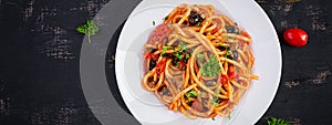 Spaghetti alla puttanesca - italian pasta dish with tomatoes, black olives, capers, anchovies