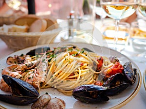 Spaghetti allo scoglio or spaghetti with seafood served in a white dish with shrimps