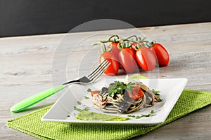 Spaghetti with black sepia, parsley and cherry tomatoes