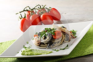 Spaghetti with black sepia, parsley and cherry tomatoes