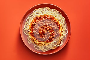 Spaghetti bolognese with fresh basil in a yellow bowl on red background. Top down view. Traditional Italian cuisine