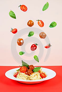 Spaghetti bolognese with meat meatballs, tomatoes and basil, flying ingredients, creative