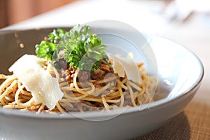 Spaghetti Bolognese with minced beef and tomato sauce garnished with parmesan cheese and basil , Italian food