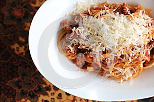 Spaghetti Bolognese with minced beef and tomato sauce garnished with parmesan cheese and basil , Italian food