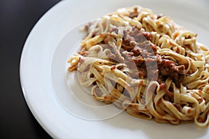 Spaghetti Bolognese with minced beef and tomato sauce garnished with parmesan cheese and basil , Italian food